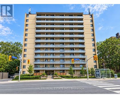 A tall apartment building with a street view in front.