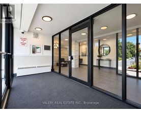 A real estate office with glass walls and a black floor.