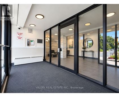 A real estate office with glass walls and a black floor.
