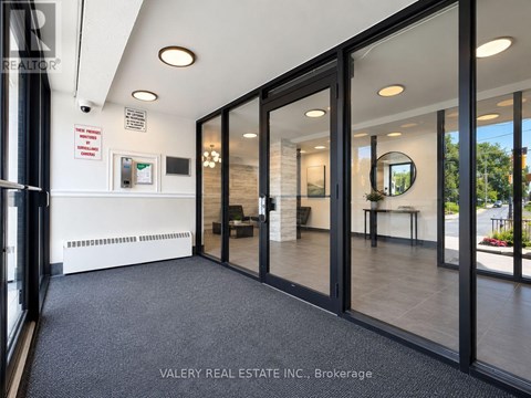 A real estate office with glass walls and a black floor.