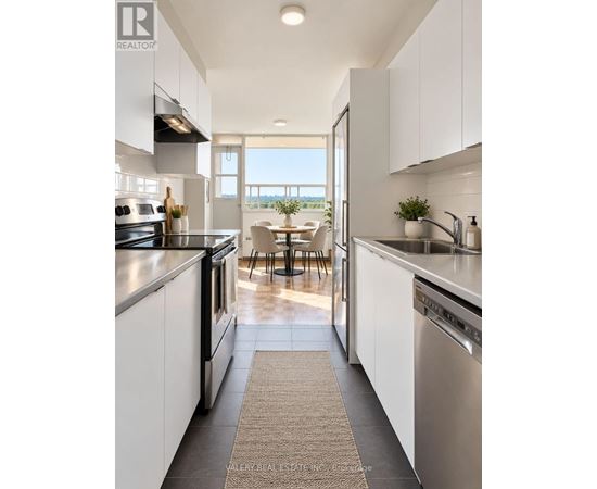 A modern kitchen with white cabinets and stainless steel appliances.