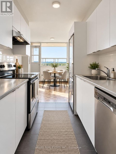 A modern kitchen with white cabinets and stainless steel appliances.