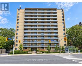 A tall apartment building with a street view in front.