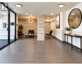 A real estate office with a glass door and a stone pillar.