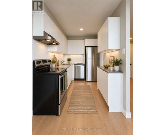 A modern kitchen with white cabinets and stainless steel appliances.