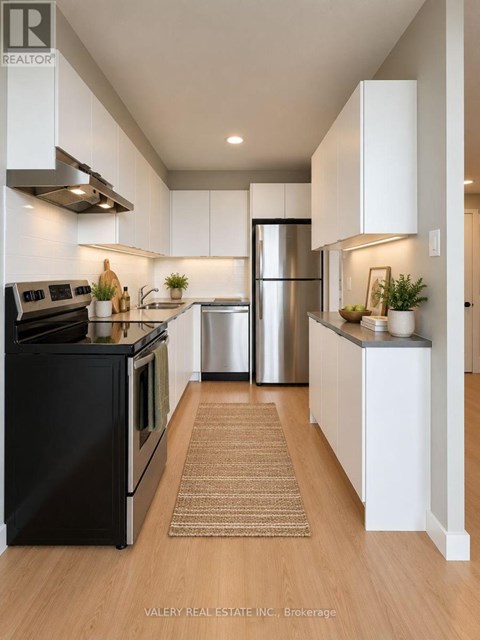 A modern kitchen with white cabinets and stainless steel appliances.