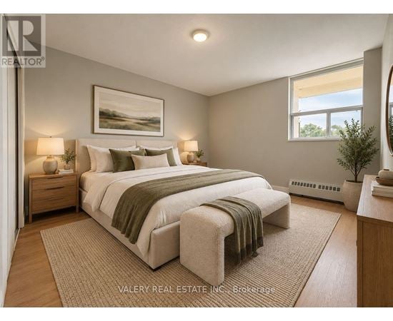 A bedroom with a large bed and a painting on the wall.