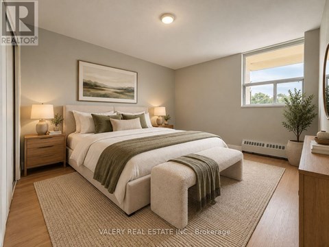 A bedroom with a large bed and a painting on the wall.