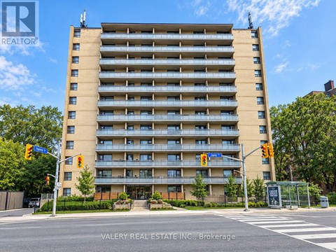 A tall apartment building with a street view in front.