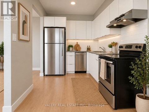 A modern kitchen with a black stove top oven and a stainless steel refrigerator.