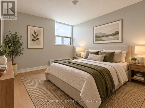 A bedroom with a large bed and a painting on the wall.