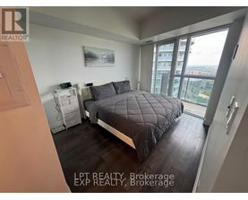 A bedroom with a large bed and a view of the city.