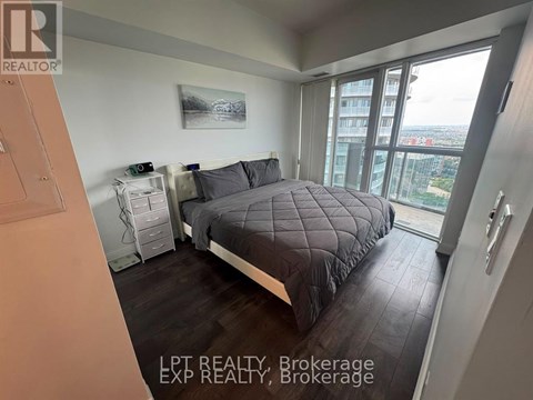 A bedroom with a large bed and a view of the city.
