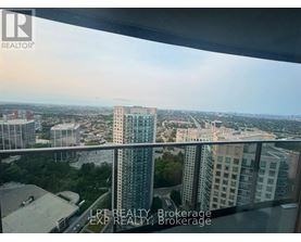 A view from a high-rise building showing a cityscape with various buildings and greenery.