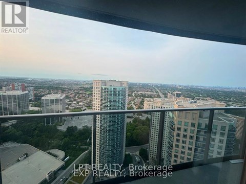 A view from a high-rise building showing a cityscape with various buildings and greenery.