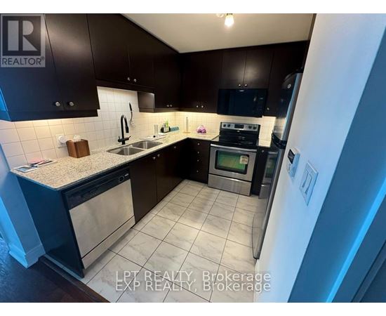 A kitchen with dark brown cabinets and a white refrigerator.