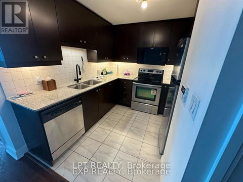 A kitchen with dark brown cabinets and a white refrigerator.