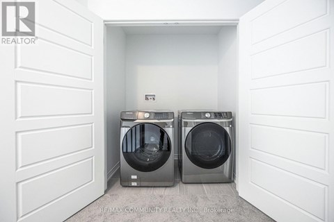 A white laundry room with two front loading washing machines.