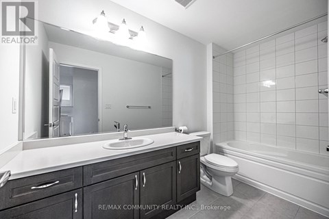 A bathroom with a sink, toilet, and bathtub.