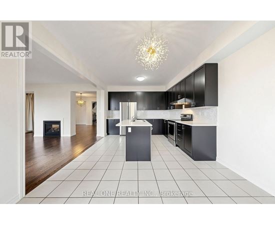 A modern kitchen with black cabinets and a white island.