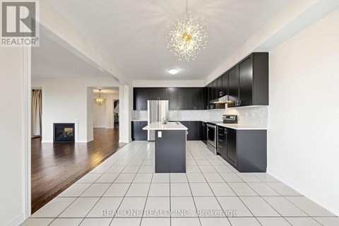 A modern kitchen with black cabinets and a white island.