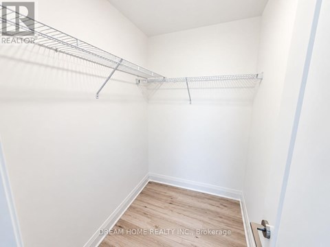 A white bedroom with a bed frame and a wooden floor.