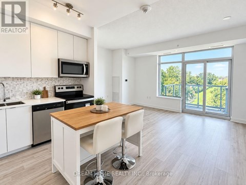 A modern kitchen with white cabinets and a wooden island.