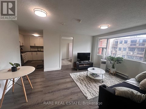 A living room with a couch, a table, and a television.