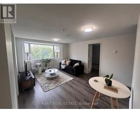 A living room with a couch, a coffee table, and a television.