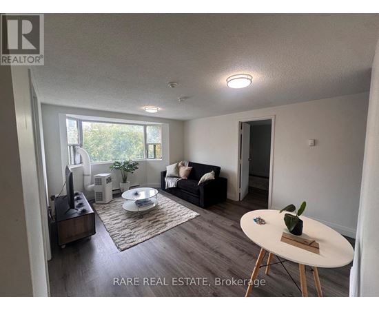 A living room with a couch, a coffee table, and a television.