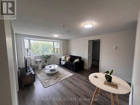 A living room with a couch, a coffee table, and a television.