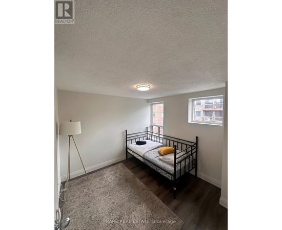 A bedroom with a bed, a floor lamp, and a window.