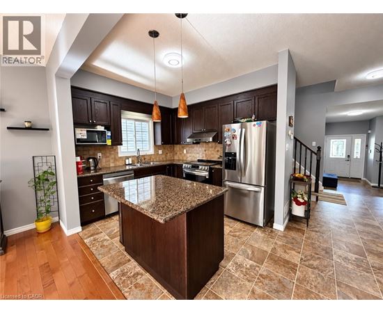 A kitchen with a granite counter top and wooden cabinets.