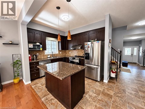 A kitchen with a granite counter top and wooden cabinets.