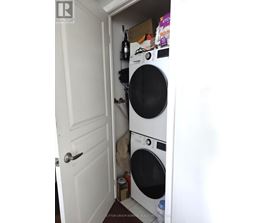 A white door is open to a small laundry room with a washer and dryer.