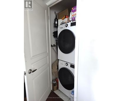 A white door is open to a small laundry room with a washer and dryer.
