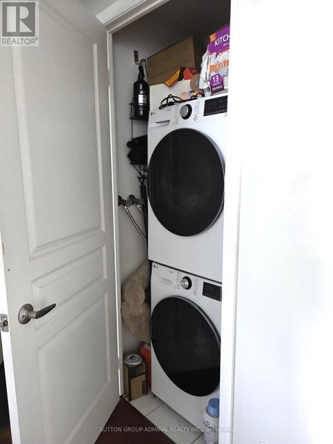A white door is open to a small laundry room with a washer and dryer.