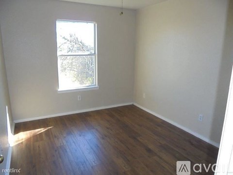 A room with wooden floors and a window.