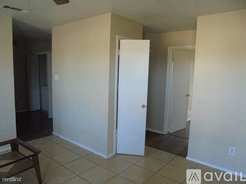 A room with a white door and a brown chair.