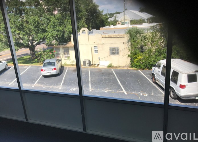 A parking lot with a white van and a grey car.