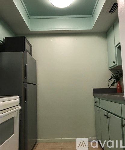 A kitchen with a black fridge and white oven.