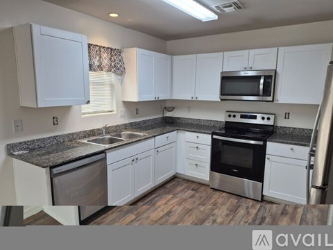 A kitchen with white cabinets and a granite countertop.