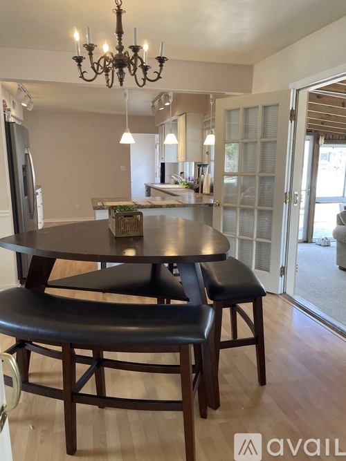 A dining room with a table and chairs.