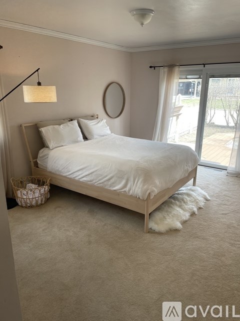 A bedroom with a large bed and a round mirror on the wall.
