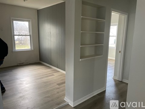 A room with a window and a shelf is available for rent.