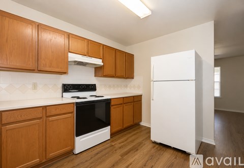 A kitchen with wooden cabinets and a white refrigerator.