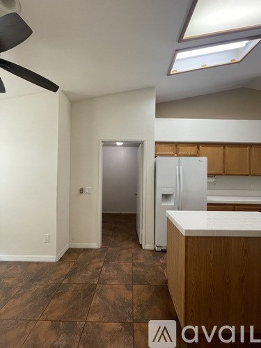 A kitchen with a refrigerator, counter, and cabinets.