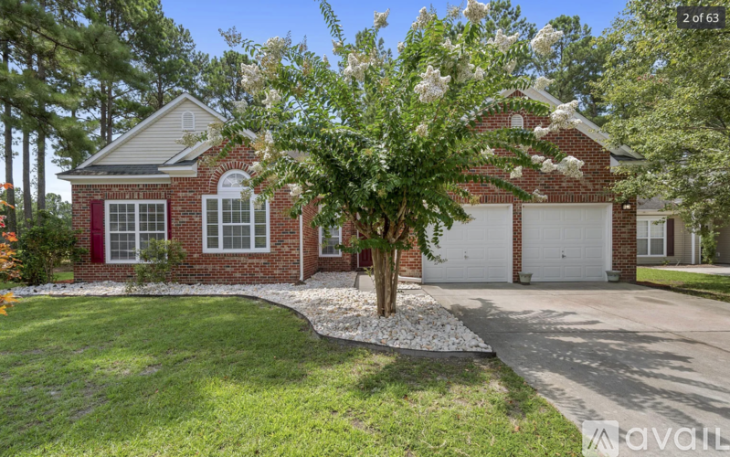 A house with a red door and a tree with white flowers in front.