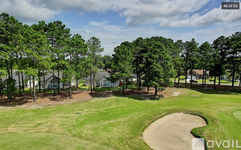 A golf course with a green and a sand trap.
