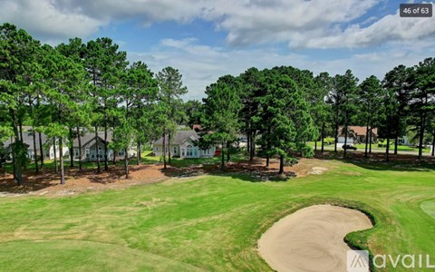 A golf course with a green and a sand trap.